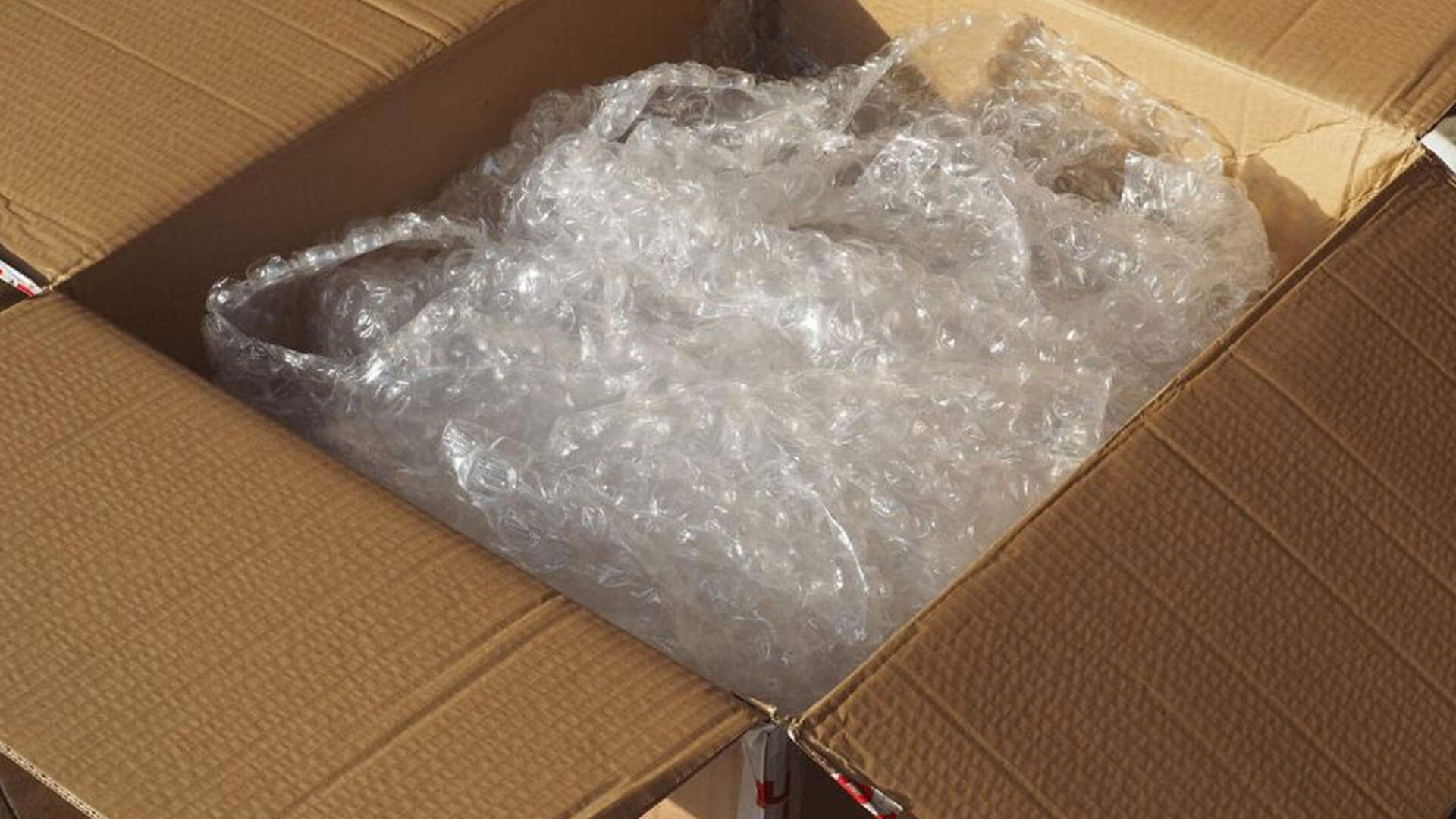 A cardboard box with excessive rolls of bubble wrap inside